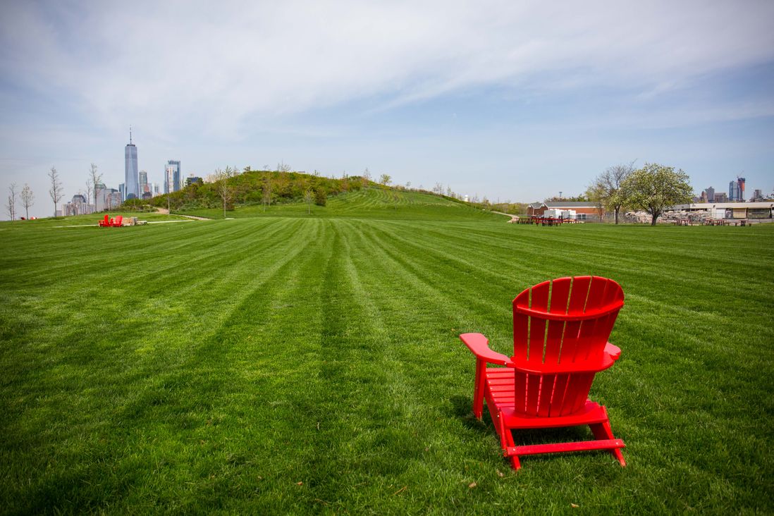 a red adirondack chair in a field